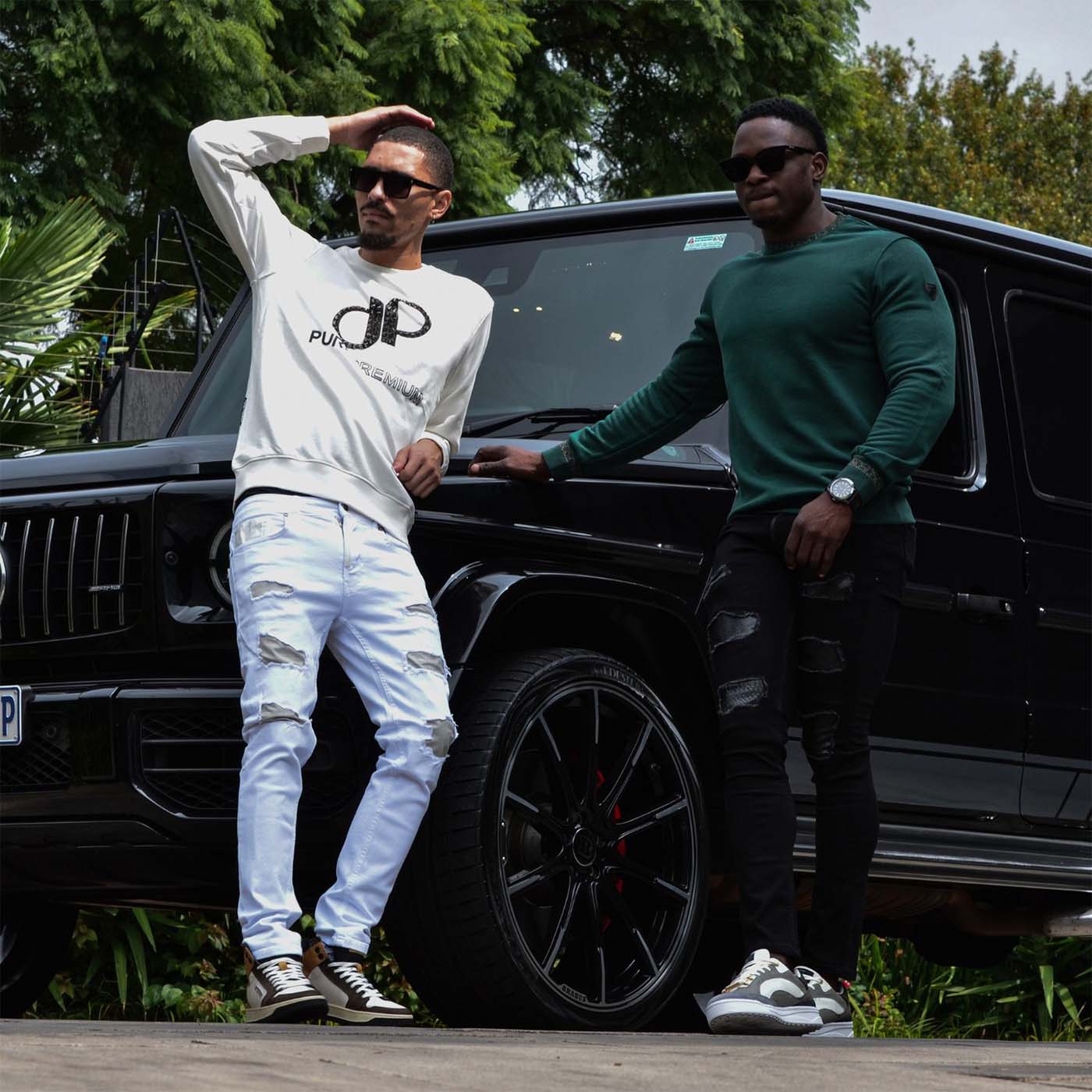 stylish-duo-in-pure-premium-gear-posing-with-suv